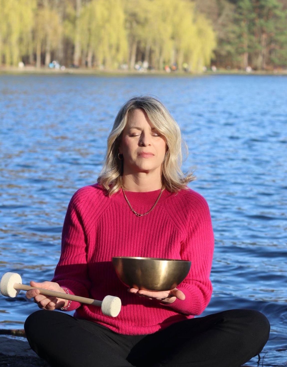 Eva Brandt mit Klangschale am Wasser